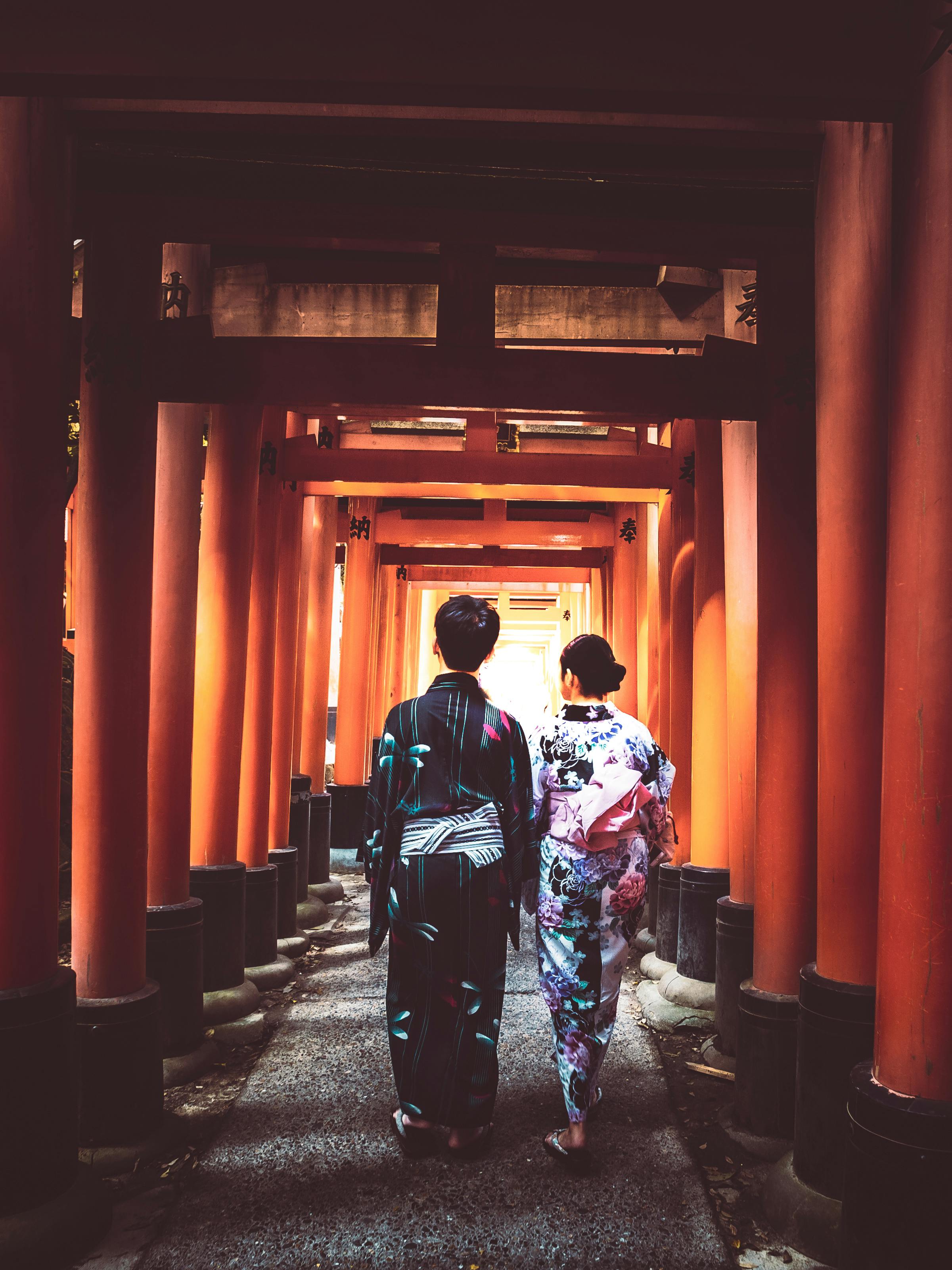 Couple wearing kimono walking through a wooden hallway